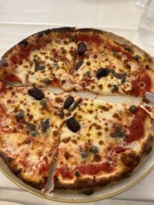 Pizza with olives on a white plate