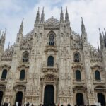 Facade of Milan Cathedral under a cloudy sky