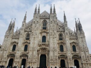 Facade of Milan Cathedral under a cloudy sky