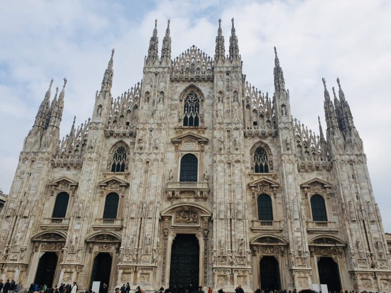 Facade of Milan Cathedral under a cloudy sky