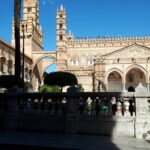 Fassade der Kathedrale von Palermo mit Palmen unter blauem Himmel