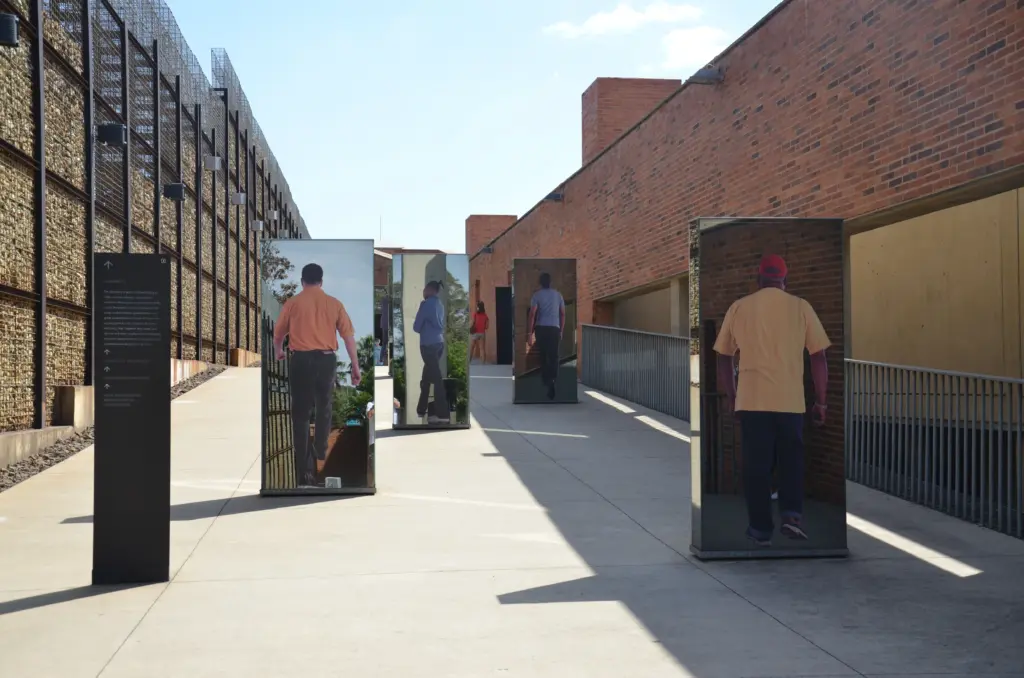 Besucher gehen durch die Eingangstore des Apartheid-Museums