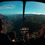 Helicopter cockpit view over a mountain canyon