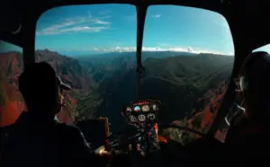 Helicopter cockpit view over a mountain canyon