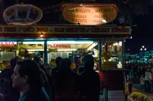 Crowd in front of an illuminated fast food stall at night