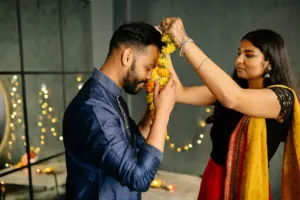 Woman placing a flower garland on a man at a wedding