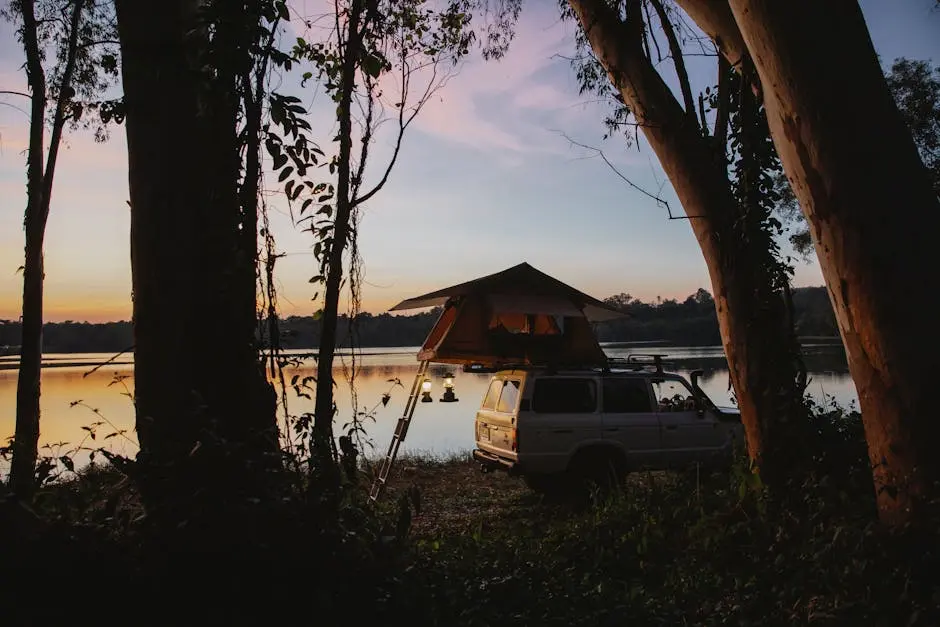 Tent and car camping by a lake at sunset