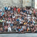 Große Gruppe von Menschen sitzt auf Steinstufen