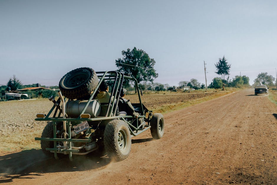 Dune buggy driving on a dusty off road track