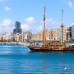 Wooden sailing ship in Sliema harbour in front of modern buildings