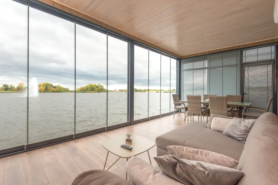 Modern glass walled living room with lake view