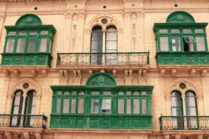 Fassade eines maltesischen Stadthauses mit grünen geschlossenen Holzbalkonen