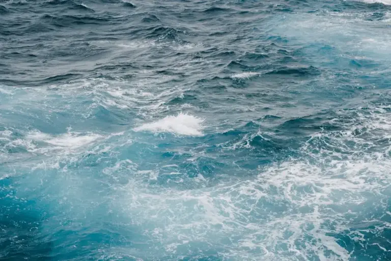 Churning deep blue ocean waves with white foam