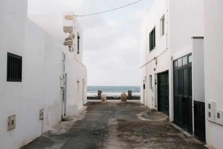 Weiß getünchte Gasse führt zum Meer in einem spanischen Dorf