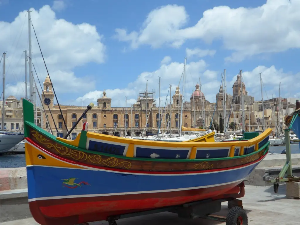 Colourful luzzu fishing boat in front of Valletta
