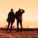 Couple looking out over the landscape at sunset