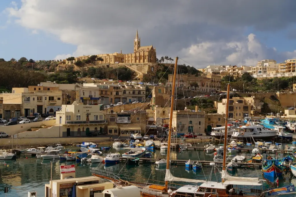 Hafen und Kirche auf dem Hügel auf Gozo