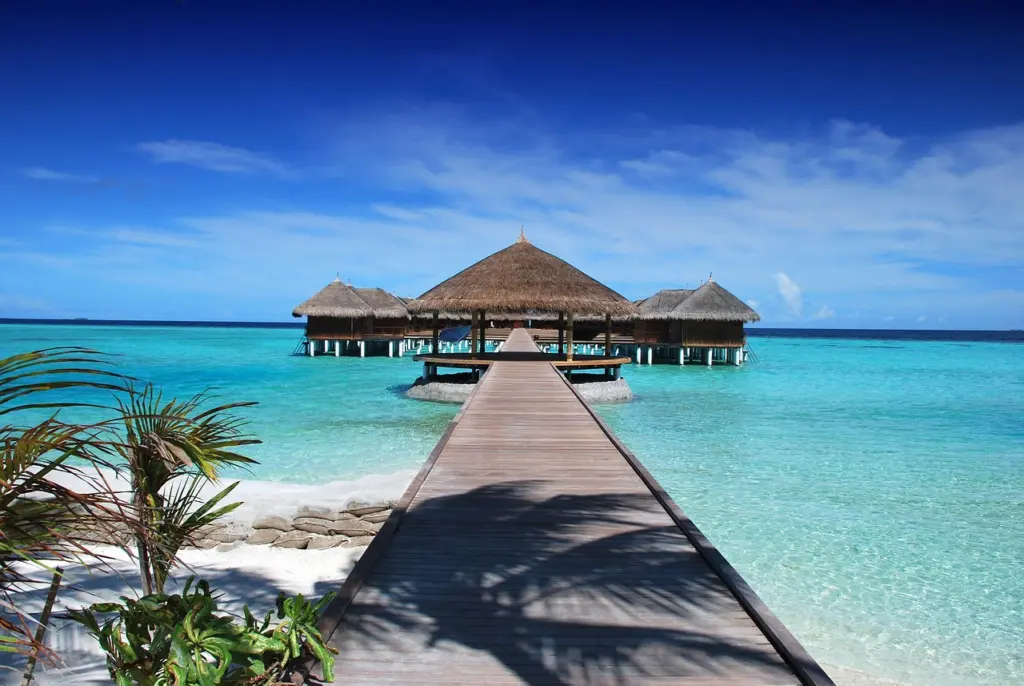 Überwasserbungalows über einer türkisfarbenen Lagune auf den Malediven