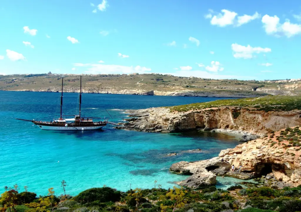 Sailing ship anchored in a turquoise bay off Comino