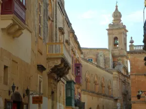 Straße mit Kalksteinhäusern und Kirchturm auf Malta